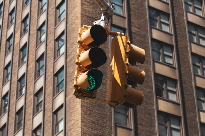 A traffic light on a street corner with a green signal